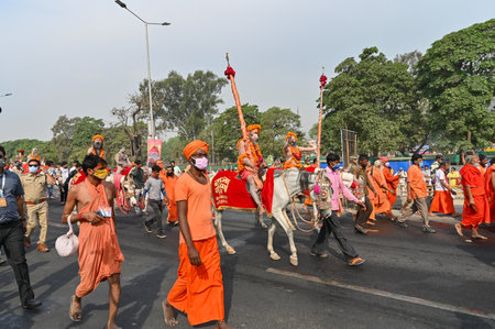 Haridwar, Uttarakhand, India - 13th April 2021 : Maha Kumbhmela event. Sadhus, sanyasis in bright saffron dresses walking in procession for shahi snaan on Holy river Ganges. Famous Hindu event.のeditorial素材