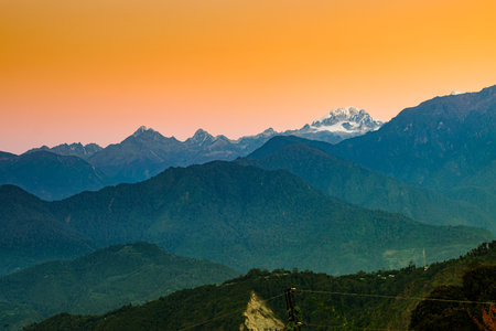 Beautiful first light from sunrise on Mount Kanchenjugha, Himalayan mountain range, Sikkim, India. Orange tint on the mountains at dawnの写真素材