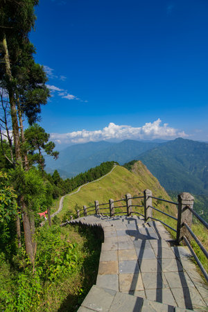 Stair case from foreground to middleground in the frame, view of Tarey Bhir point, favourite tourist spot. The word 'Bhir' means cliff in the local Nepal language, about 10,000 feet long path, in Sikkim, India.の写真素材