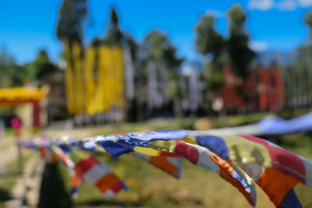 Colourful Buddhist prayer flags flying at beautiful Rinchen Chholing Monastery with , clear blue sky...