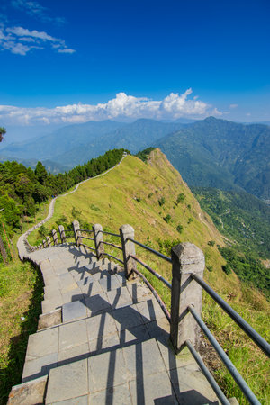 Stair case from foreground towards Himalayan mountains in horizon, Tarey Bhir point, famous tourist spot, Sikkim, India. The word 'Bhir' means cliff in the local Nepal language,long path for tourists.の写真素材