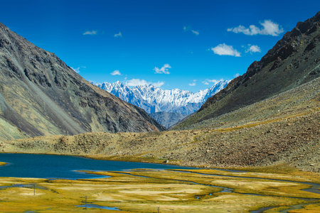 View of lake and river with snowy mountain peak at Chang La , southern pass, a high mountain pass in Ladakh in the Greater Himalaya between Leh and the Shyok River valley. Leh, Ladakh, India.の写真素材