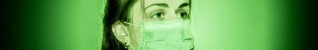 a catastrophe scene of a sad woman with mask in medical green tonesの写真素材