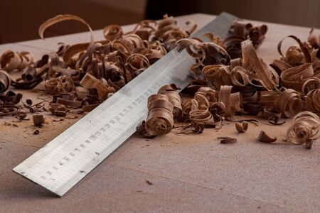 a steel metric ruler in wood chips on the tableの写真素材
