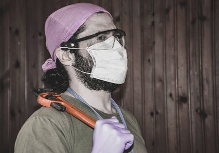 a male medical worker with a pipe wrench on his shoulder "first of may" - labor day iの写真素材