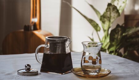 soft pastel scene of a glass teapot with hot tea and classic turkish tea glass on the tableの写真素材