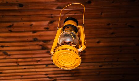 very old, used vintage metal gas light still active, as an ancient rusty object hanging on the ceilingの写真素材