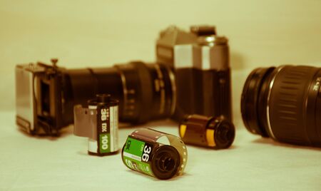 unused 36 exposure BW film rolls perspective preferentially placed with old ancient cameras and lenses in blur background, foggy closeup sceneの写真素材