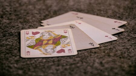 closeup scene of a hand of poker, playing cards opened on the table in a game, poker, four of a kind and queen .の写真素材