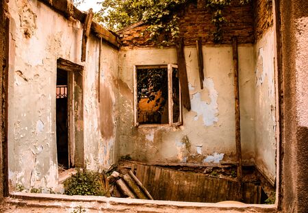 inside of an abandoned old tumbledown house, uninhabitable condition, floor collapsed, all paints peeled off from the walls and ramshackle wooden framesの写真素材