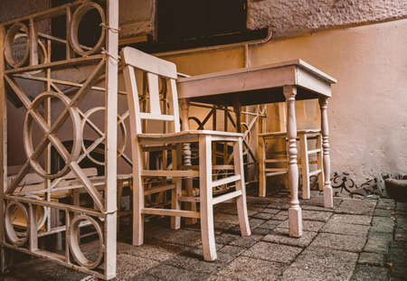 sweet creamy white wooden table and two wooden chairs stay on the nice garden with evening dim light. from the bottom angle.の写真素材