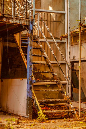 very old, ramshackle iron stairs in an abandoned place, dramatic scene of disrepair, close-up.の写真素材