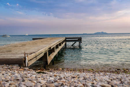 an old wooden pier stretches into the open seaの写真素材