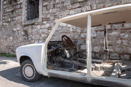 an old model scrap white vehicle abandoned with panels, doors, seats and upholstery removedの写真素材
