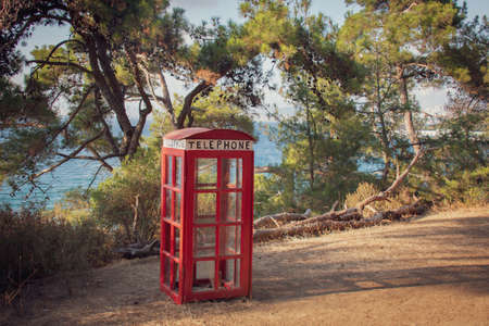 antique english telephone booth as a famous image set up in a forest park by the sea. general plan.の写真素材