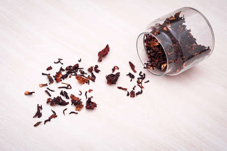 Hibiscus herbal tea spilled from a glass jarの写真素材