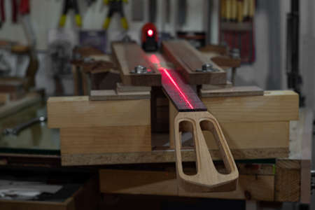 a scene of neck straight level control and assembly with red laser in an instrument making workshopの写真素材