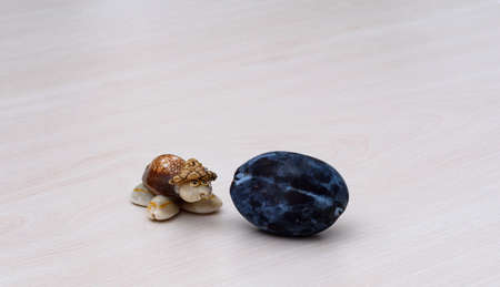 a small tortoise trinket, a decorative object, with a black plum in front.の写真素材