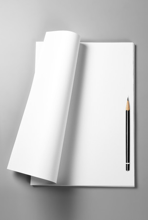 Pile of blank sheets of paper with curled upper page and pencilの写真素材