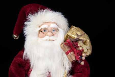 Santa Claus in glasses with gifts closeup portrait on black backgroundの写真素材