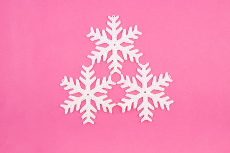 Three Christmas decoration white snowflakes on rose background. Useful for any type of Christmas cardの写真素材