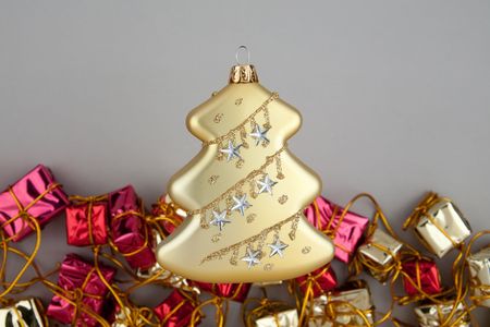 Christmas decoration gold tree with garland from red and gold gift boxes on gray backgroundの写真素材