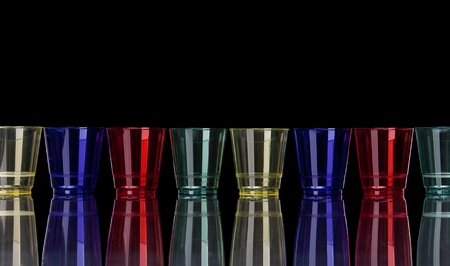 Colored plastic glasses on black with reflectionの写真素材