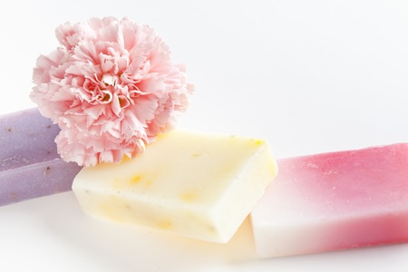 Three soap bars with natural ingredients and flower