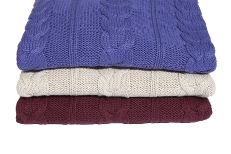 Fragment of three folded sweaters on whiteの写真素材