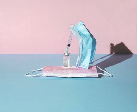 Boat made of face masks, syringe and vial on pastell blue and pink background, minimal abstract...