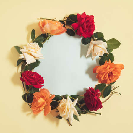 Wild roses lay down in a circle on yellow background, vintage flat lay romantic concept with white copy spaceの写真素材
