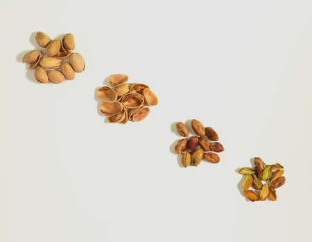 Pistachio fruit, shell and kernels lying downo on a white background, top view, minimal healthy food conceptの写真素材