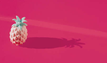 Colorful artificial pineapple stand on pastel magenta background. Horizontal composition with copy space, minimal summer decoration conceptの写真素材
