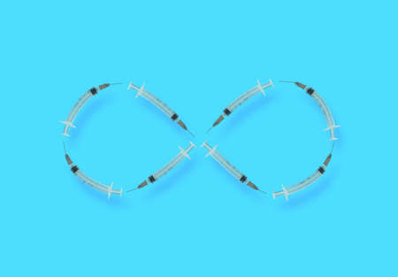 Infinity symbol made of curved syringes. Minimal flat lay composition on cyan background, global...