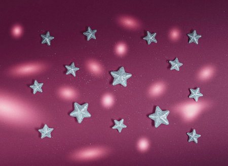 Decorative silver stars and circles of light on dark red background. Minimal flat lay pattern composition , abstract Cristmass and New Year retro aesthetic decorative conceptの写真素材
