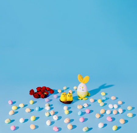 Easter Chickens, eggs and res roses on cyan background. Minimal vertical composition with copy space, funny spring and Easter decoration conceptの写真素材