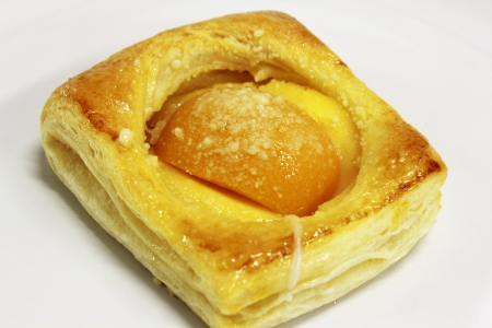 A peach Danish on a white backgroundの写真素材