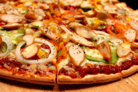 cut sausage and onion pizza on woodの写真素材