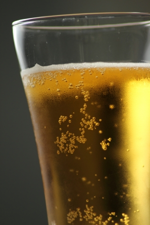 Close up of beer glass with bubbles and foam の写真素材