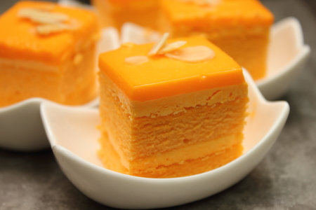 A orange cake with almond slice on top