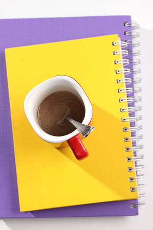 A Notebook and coffee on table top view.の写真素材