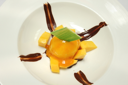 Scoop of homemade mango ice cream with fresh mangos.の写真素材