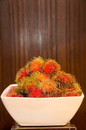 A Rambutan in bowle on a wood background.の写真素材