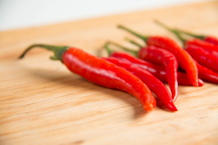 Closeup of  fresh raw red hot chili peppers on wood