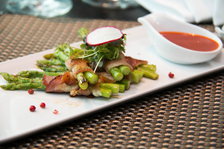 A Asparagus wrapped in bacon with italian sauceの写真素材
