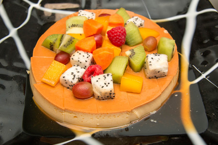 A Deliciuos caramel custard close shot with fresh fruit.の写真素材