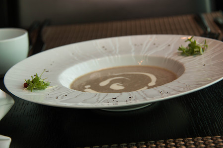 a bowl of mushroom soup with a swirl of cremeの写真素材