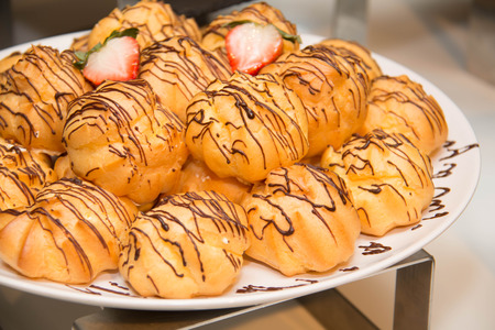 Eclair with chocolate fudge on white plate