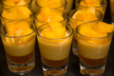 Delicious dessert with mango mousse in glassの写真素材