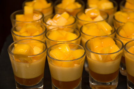 Delicious dessert with mango mousse in glassの写真素材